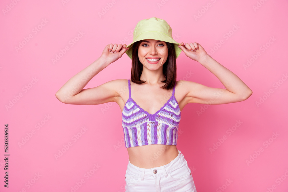 Photo of young satisfied glad lady toothy smile hands touch panama hat isolated on pink color background Photo of young satisfied glad lady toothy smile hands touch panama hat isolated on pink color background