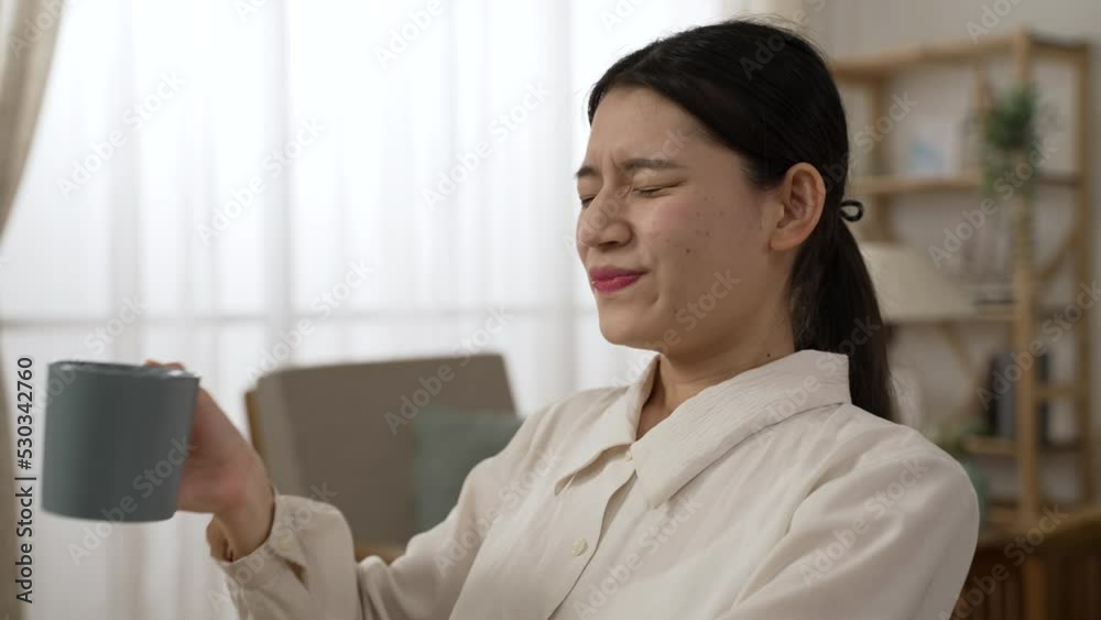 shoulder shot of a happy asian businesswoman enjoying refreshing morning tea and looking into distance with a satisfied smile on face while working from home shoulder shot of a happy asian businesswoman enjoying refreshing morning tea and looking into distance with a satisfied smile on face while working from home