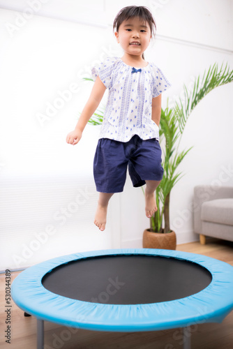 トランポリンでジャンプして遊ぶ5歳の女の子