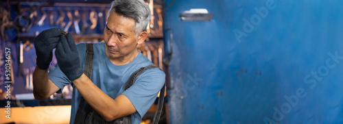 Portrait senior asian male mechanic engineering working on tools box background. Repair specialist, technical maintenance. Small business owner.