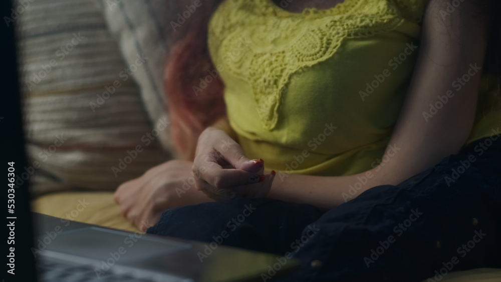 Close up shot hands of woman with physical disability who gesturing during talking via online video call on laptop sitting on a couch