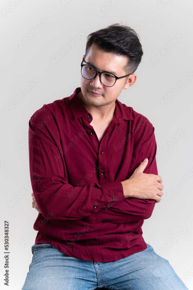 Portrait of Handsome young asian man posing on grey background. dressed casually with happy and self-confident positive expression with crossed arms. Concept good attitude of adult. Portrait of Handsome young asian man posing on grey background. dressed casually with happy and self-confident positive expression with crossed arms. Concept good attitude of adult.