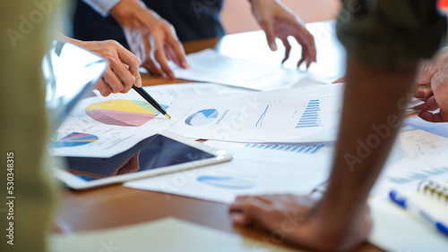 Working team member discussing or brainstorm about company profit sale volume chart and data analysis graph in the meeting with smart device business and financial concept