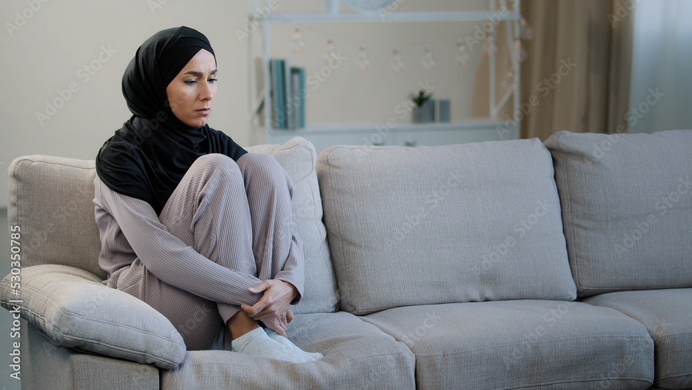Lonely upset sad muslim young woman sit on sofa health problem interrupted pregnancy divorce islamic unwell girl in hijab feeling anxiety depressed frustrated unhappy female difficult period of life Lonely upset sad muslim young woman sit on sofa health problem interrupted pregnancy divorce islamic unwell girl in hijab feeling anxiety depressed frustrated unhappy female difficult period of life