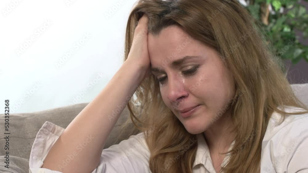 Sad woman crying on the couch Sad woman crying on the couch