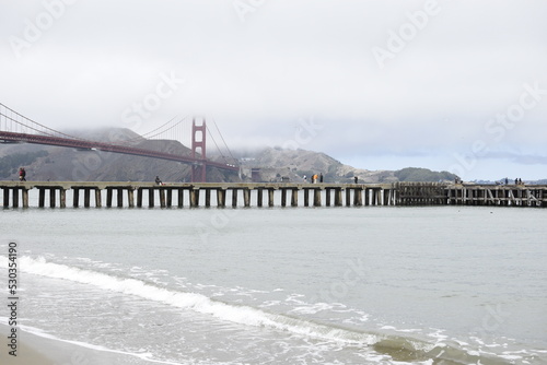 View of a pier in San Francisco with the Golden Gate in the background.