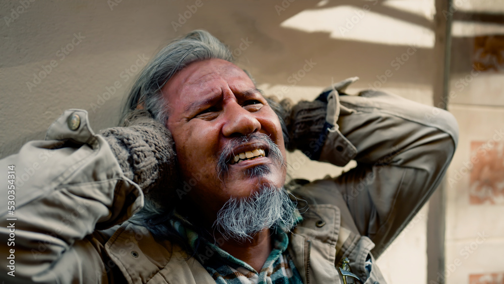 Obraz premium Close-up of the face of a dirty-dressed, long-haired, long-haired old man who is homeless. are showing signs of severe stress because he had no food to eat and no work to sleep on the streets.