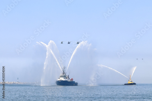 Rescue tug at sea. Water splash. Fire ships. Helicopters