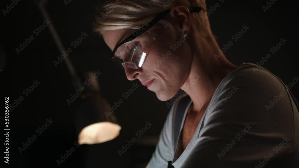 Close up of female worker in metal workshop working, wearing safety glasses. Close up of female worker in metal workshop working, wearing safety glasses.