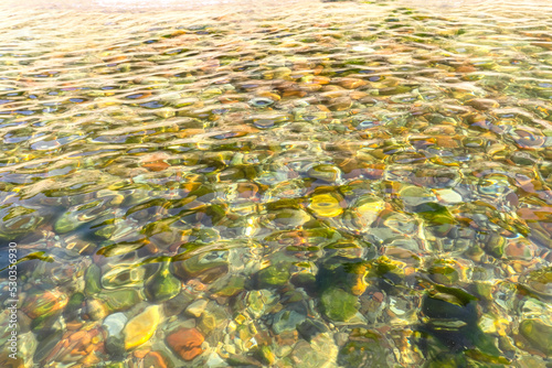 Clear sea water. Small stones at the bottom. Texture transparent clear water