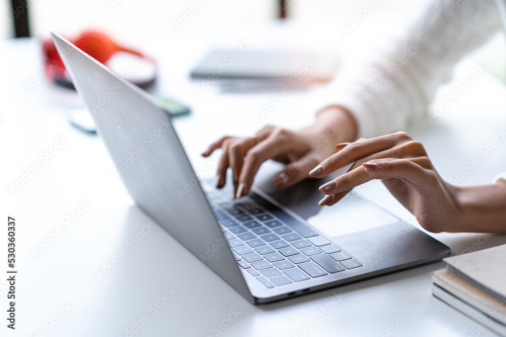 cropped shot of woman hands typing on laptop keyboard at the office. cropped shot of woman hands typing on laptop keyboard at the office.