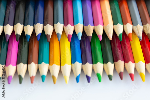 Set of colored watercolor pencils arranged in a semicircle isolated on a white background