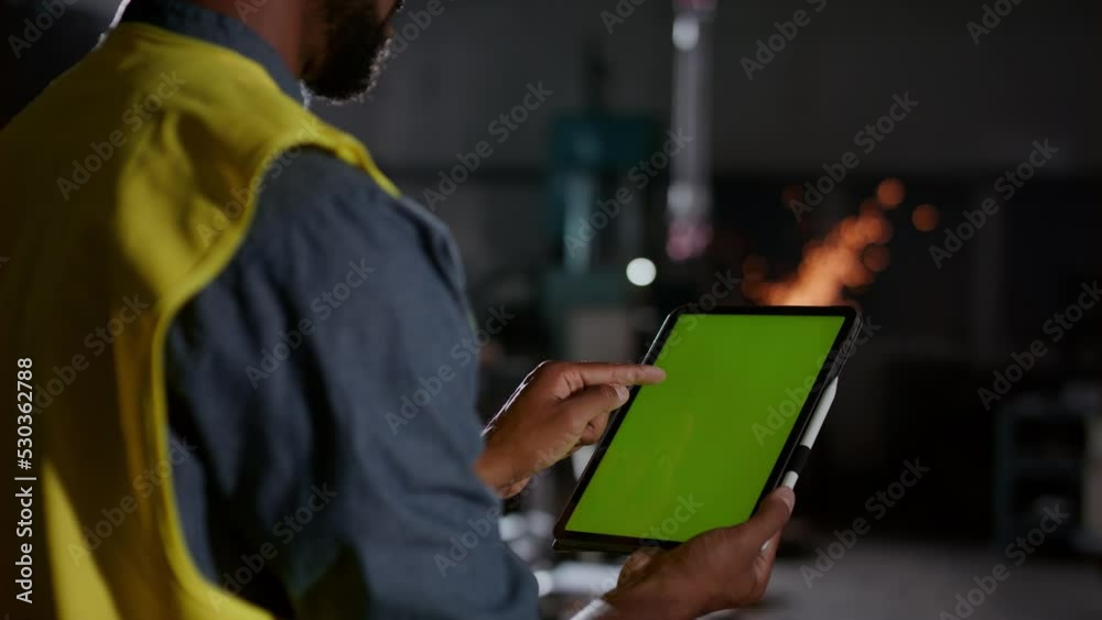 Close up back view of industry workder using tablet with green screen. Close up back view of industry workder using tablet with green screen.