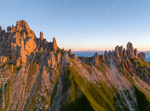 Sunrise in the Dolomites mountains with fog and mist rolling around the peaks. Hiking path leading to the hills. 