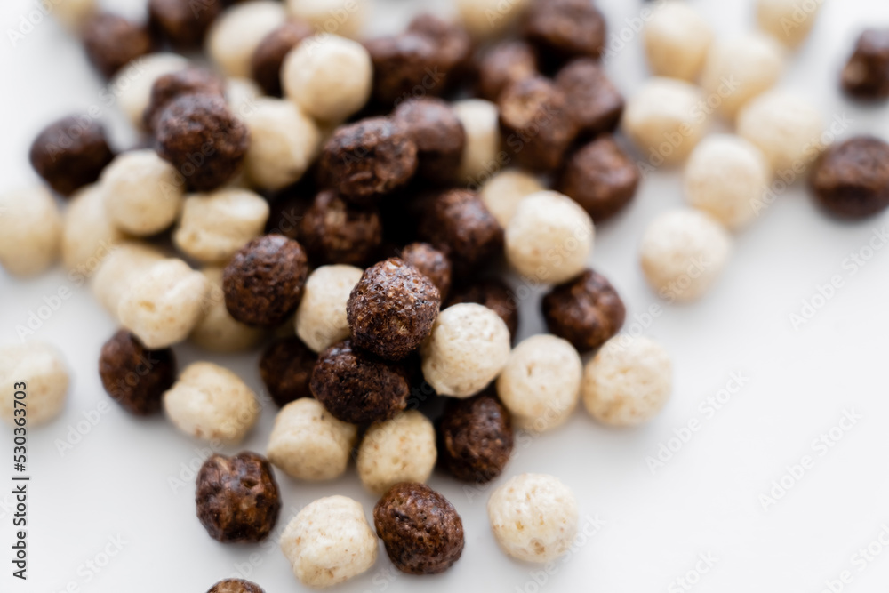 close up view of cereal balls with chocolate and vanilla flavors isolated on white. close up view of cereal balls with chocolate and vanilla flavors isolated on white.