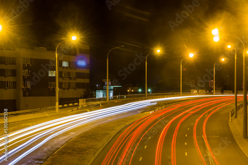 View from the bridge to the night highway with traces of car headlights..