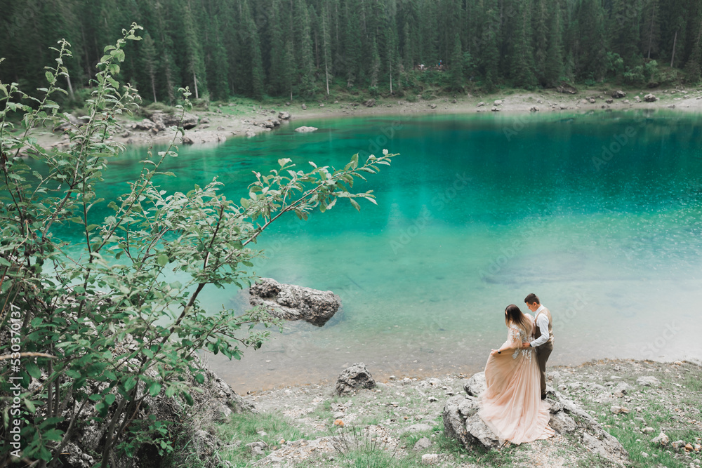 Obraz premium Beautiful modern couple near a lake in the mountains make wedding photos
