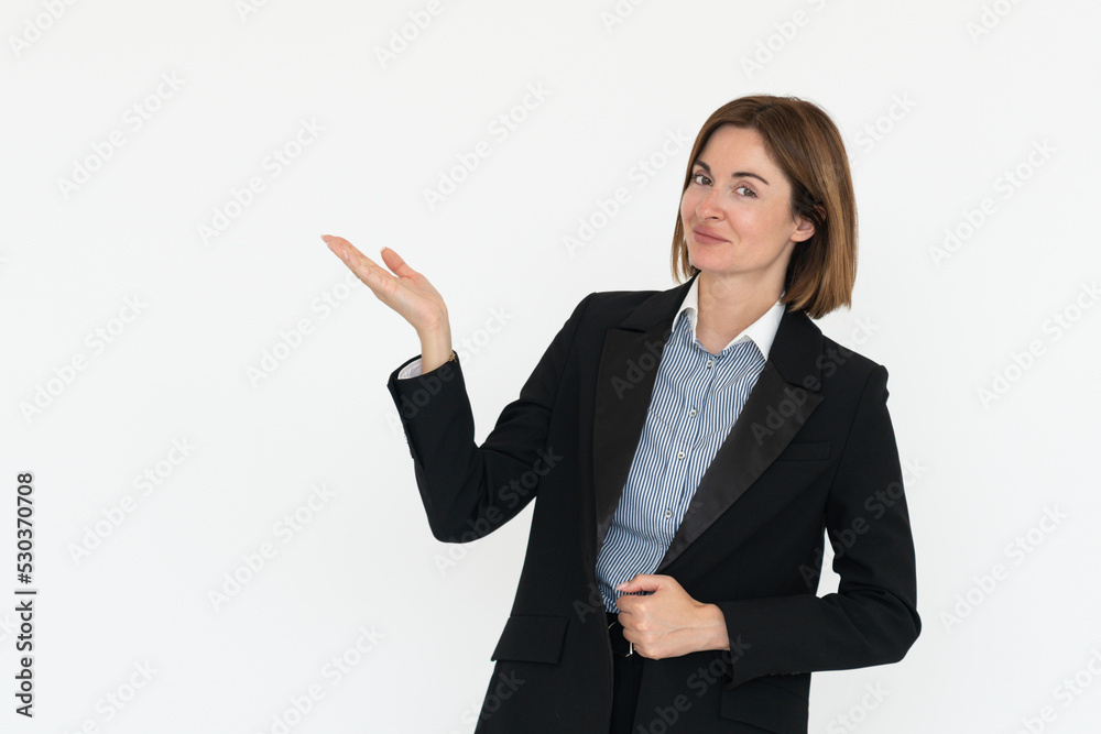 Young attractive and smiling businesswoman in black suit standing and pointing on free space isolated on white background Young attractive and smiling businesswoman in black suit standing and pointing on free space isolated on white background