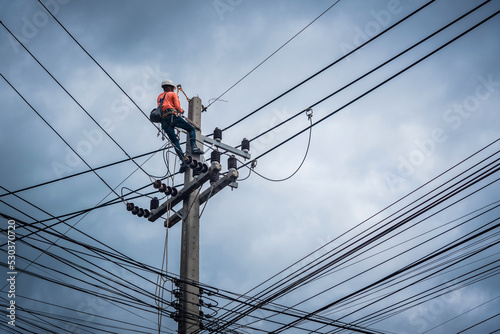Electricians are climbing on electric poles to install and repair power lines.