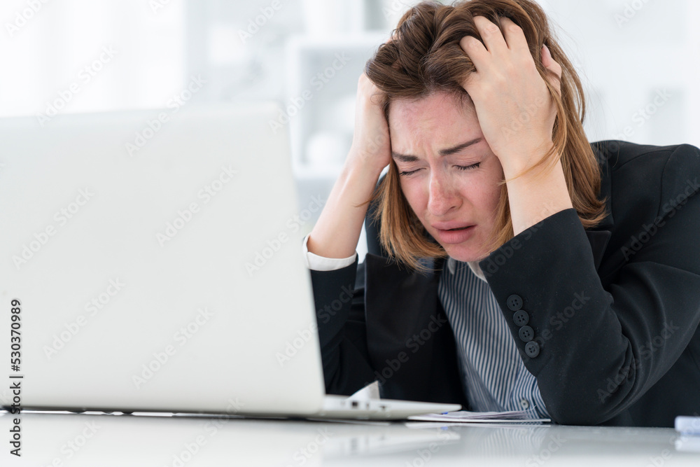 Tired frustrated and overworked business woman sitting in the office and thinking about problems in business Tired frustrated and overworked business woman sitting in the office and thinking about problems in business