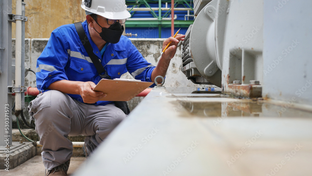 Industrial electrician wearing safety helmet Visual check Induction motor electrical equipment.