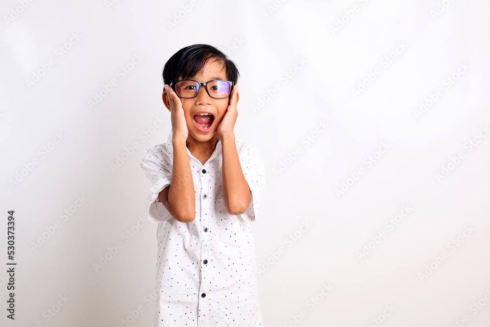 Surprised asian schoolboy standing while shouting and looking at the camera. Isolated on white Surprised asian schoolboy standing while shouting and looking at the camera. Isolated on white