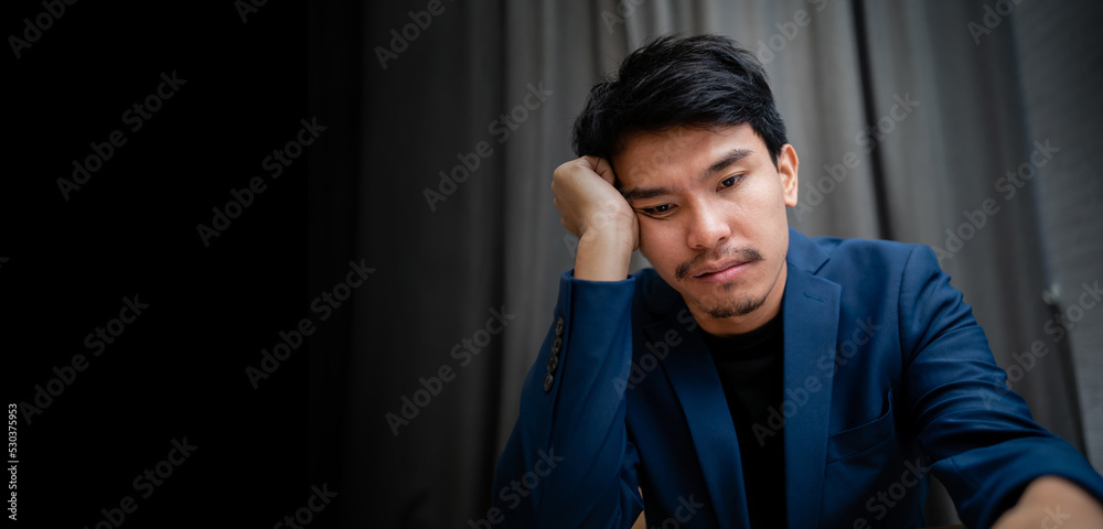 A young businessman in formal clothes sits at a desk in his office and looks in despair at a laptop screen. A disappointed male office worker in a suit has been filed for dismissal or bankruptcy. A young businessman in formal clothes sits at a desk in his office and looks in despair at a laptop screen. A disappointed male office worker in a suit has been filed for dismissal or bankruptcy.