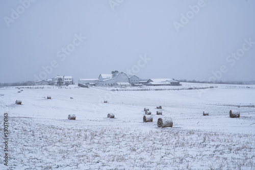 Hay bales in a farm field on a snowy Amish farm in the winter in Holmes County, Ohio