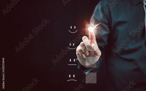 Customer Service Experience and Satisfaction Business people are touching the virtual screen on the happy smiley face icon to give you excellent service quality rating satisfaction.