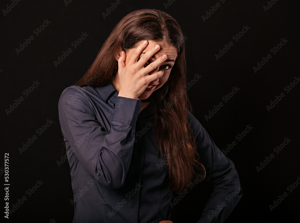 Happy chuckling fun business beautiful woman covering the mouth the hand on blue shirt on black background with empty copy space. Closeup portrait Happy chuckling fun business beautiful woman covering the mouth the hand on blue shirt on black background with empty copy space. Closeup portrait