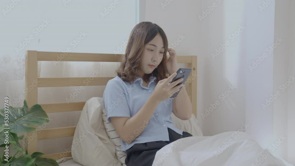 Holiday concept of 4k Resolution. Asian girls playing cell phones in the bedroom. Holiday concept of 4k Resolution. Asian girls playing cell phones in the bedroom.