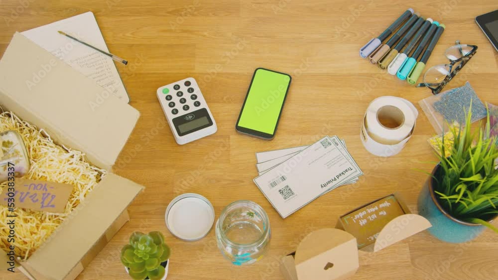 Overhead shot of contactless card payment terminal with mobile phone on desk - shot in slow motion Overhead shot of contactless card payment terminal with mobile phone on desk - shot in slow motion