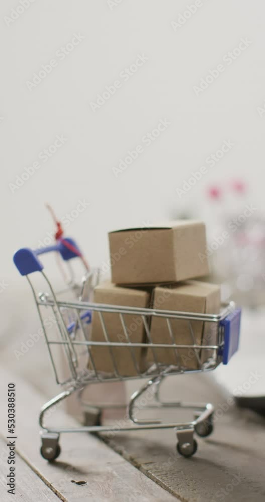 Vertical video of shopping cart with boxes on white background Vertical video of shopping cart with boxes on white background