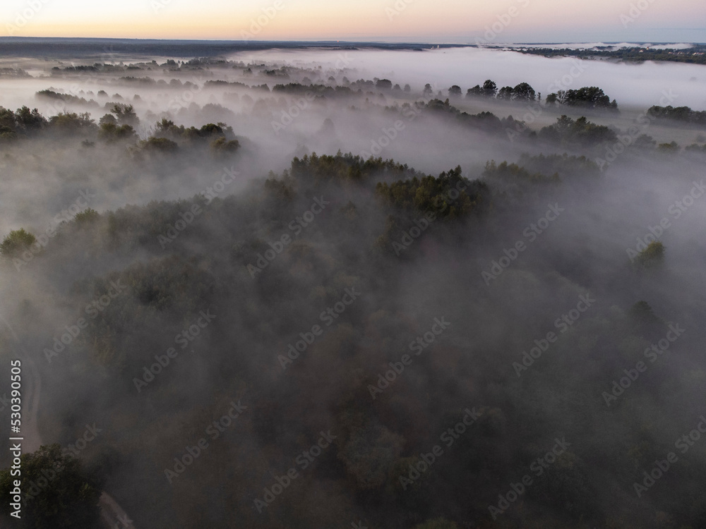 Pictures of the drone flight over the fog. River, forest, fields and meadows on a misty summer dawn. Summer.