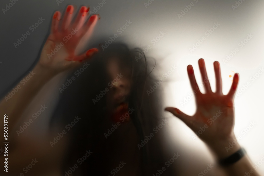 Shadowy figure with blood behind glass - horror background Shadowy figure with blood behind glass - horror background
