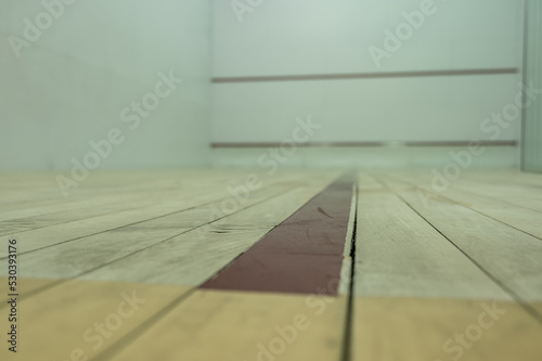 selective focus on a section of wood planking at floor level inside a racquet ball court © Lost_in_the_Midwest