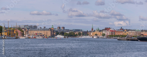 Panorama view over the bay Ladugårdsviken, commuter boats, sail boats, hotels, skyline with skyscrapers and apartment houses, a sunny autumn day in Stockholm