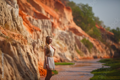 A beautiful young woman walks along a stream in the tropics. Vietnam Mui Ne. Blonde in the tropics