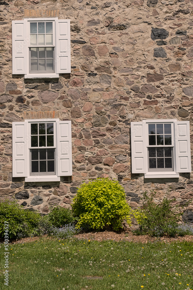 Windows with shutters on old stone house.