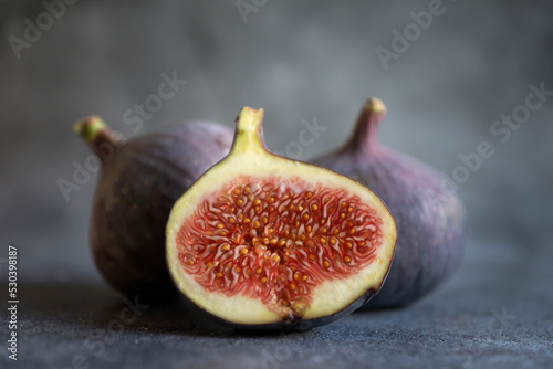 Ripe, sweet figs whole and cut on a dark background.