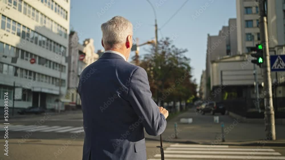 Grey-haired businessman in suit puts bag belt on shoulder Grey-haired businessman in suit puts bag belt on shoulder
