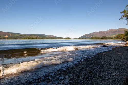 The shore of a calm lake in the Lake District on a summer sleepy day