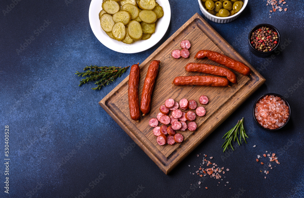 Delicious fresh smoked sausages cut with slices on a wooden cutting board