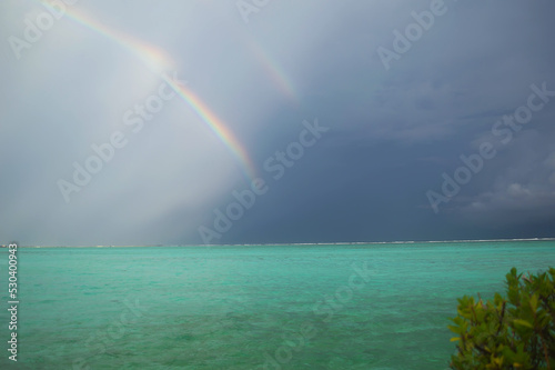 A double rainbow in gloomy weather over an Sun Island in the Indian Ocean. Rainbow after a tropical downpour in the Maldives
