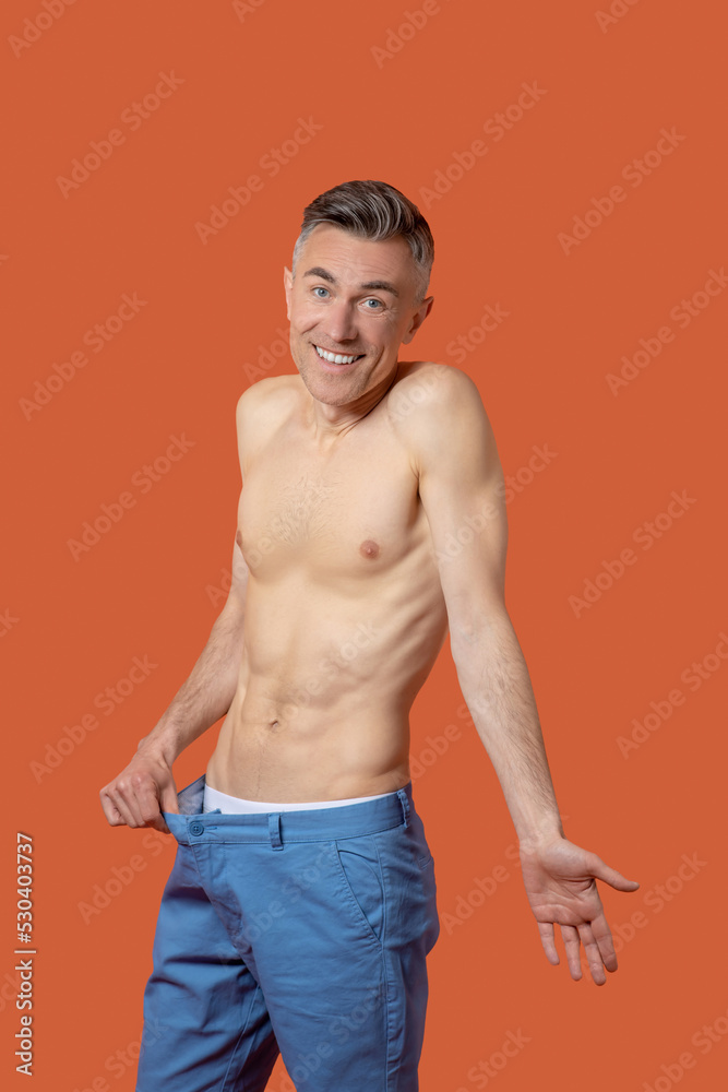 Fototapeta premium A man in shorts with flat belly looking emotional and surprised