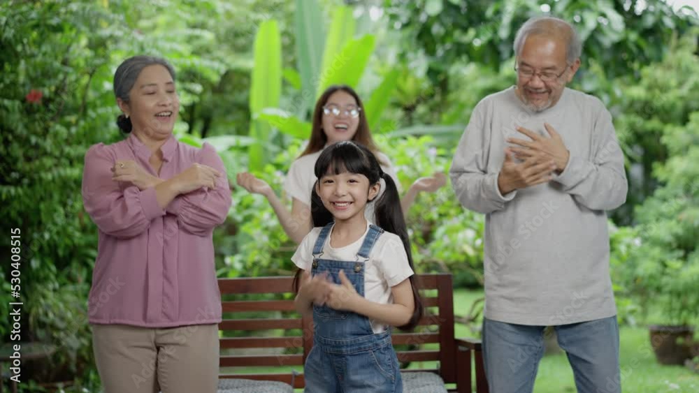 Asian happy family stay home outside backyard. Little girl with grandparents and mother dancing having fun together practice. laughing, enjoy parenting activity relationship in house. Asian happy family stay home outside backyard. Little girl with grandparents and mother dancing having fun together practice. laughing, enjoy parenting activity relationship in house.