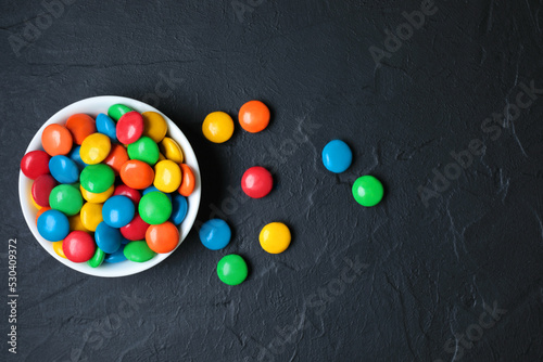 Vessel with Color Candies on black concrete background