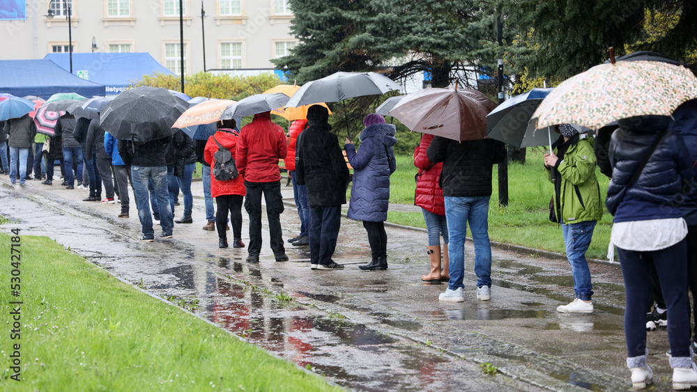  Ludzie pod parasolami czekają w kolejce do mobilnego punktu szczepień we Wrocławiu - obrazy, fototapety, plakaty 