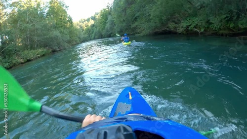 POV Caucasian man paddling blue kayak over the river, looking at beautiful nature and the kayaker moving in front of him, point of view shot.