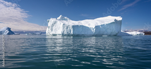 Massive icebergs with mountain backdrop in Disko Bay in Greenland photo